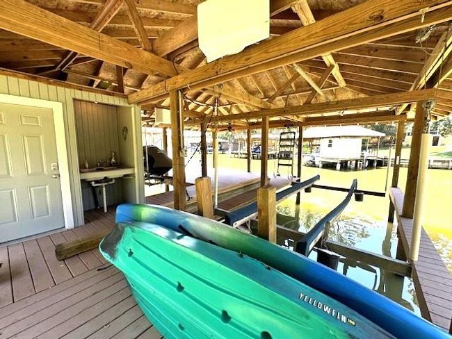 Enjoy seamless waterfront living with a convenient fish cleaning station, boat lift, and easy access to the spacious boathouse storage room. | Image 42