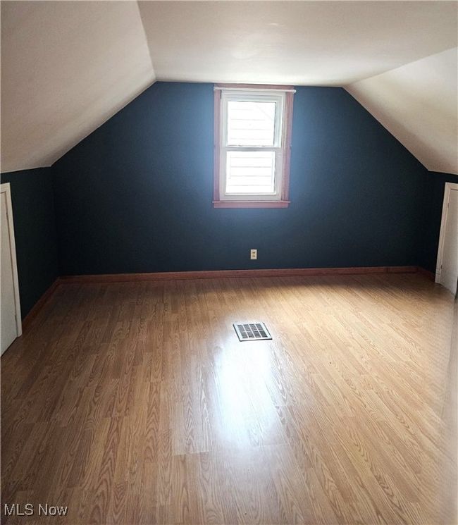 Additional living space featuring vaulted ceiling, wood finished floors, and baseboards | Image 4