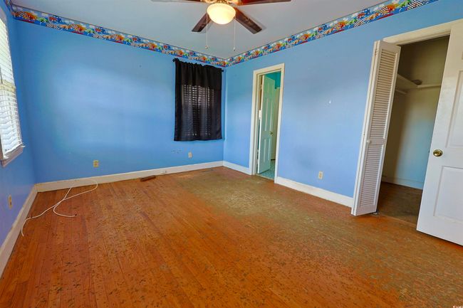 Unfurnished bedroom featuring a closet, wood finished floors, and ceiling fan | Image 22