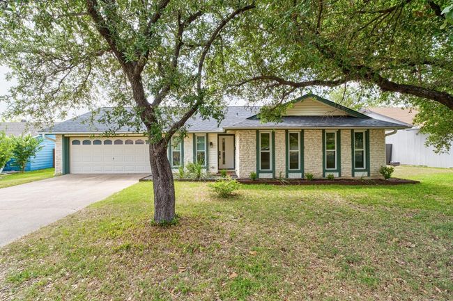 Ranch-style home with driveway, an attached garage, a front yard, stone siding, and a shingled roof | Image 28
