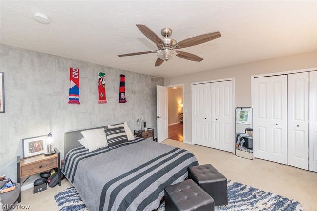 Bedroom with light colored carpet, two closets, and ceiling fan | Image 34
