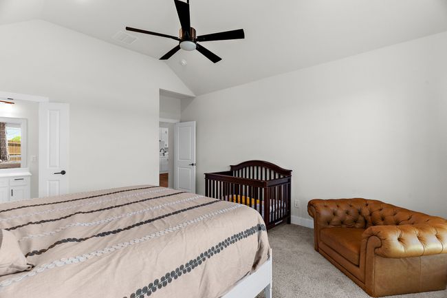 Bedroom featuring light colored carpet, a ceiling fan, baseboards, and high vaulted ceiling | Image 26