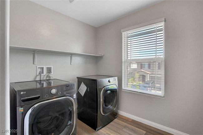 Clothes washing area featuring washer and dryer, baseboards, and wood finished floors | Image 29