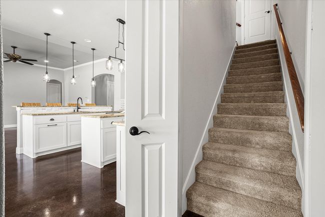 Stairway featuring a ceiling fan, arched walkways, baseboards, ornamental molding, and recessed lighting | Image 29