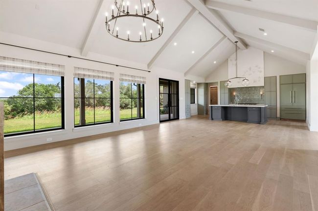 Vaulted and beamed ceilings add drama and volume to the space. Well-proportioned and balanced, this home exudes elegance and comfort. | Image 6