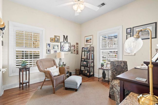 Home office with wood finished floors, baseboards, ceiling fan, and visible vents | Image 4