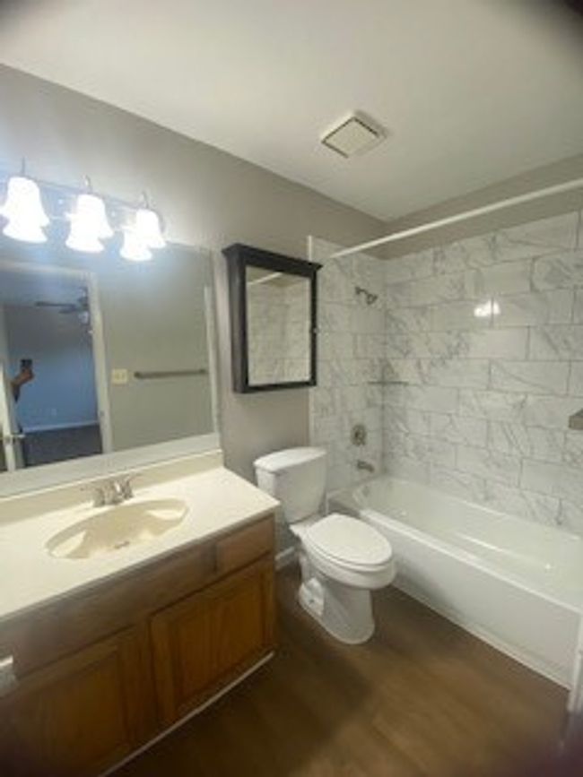 Bathroom featuring wood finished floors, vanity, bathtub / shower combination, and toilet | Image 32