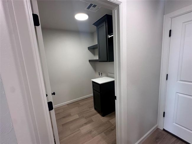 Laundry room with light wood-type flooring, cabinet space, baseboards, and washer hookup | Image 15