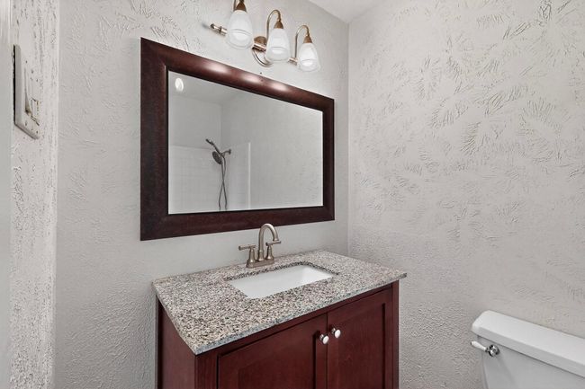 Bathroom with vanity and a textured wall | Image 17