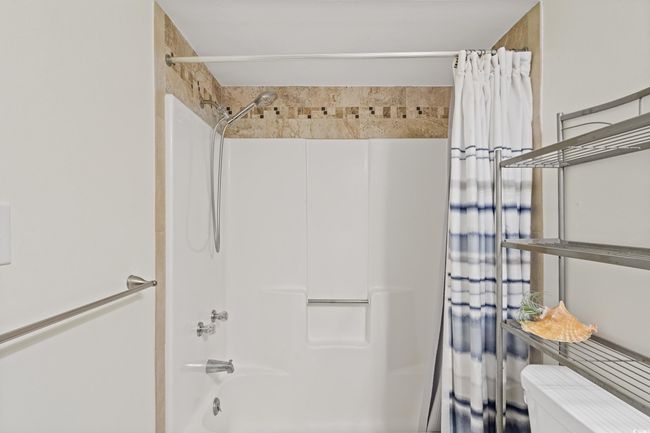 Bathroom featuring toilet and shower / tub combo | Image 31