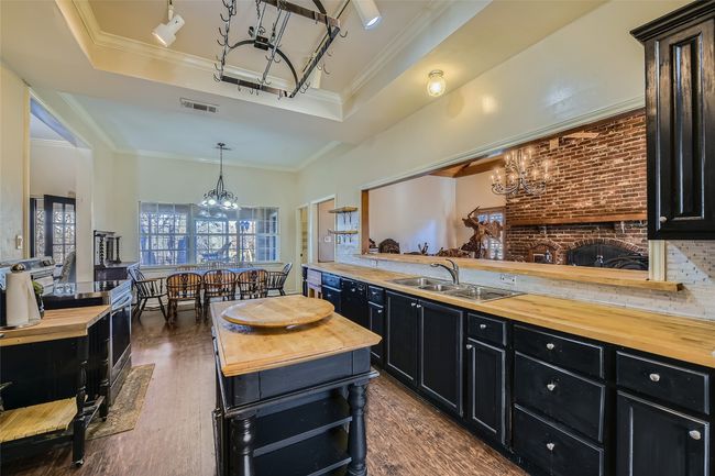 Notice the matching black cabinets and butcher block counter/table tops throughout your country kitchen. | Image 17