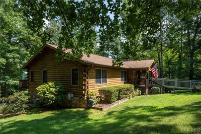 View of home's exterior with a wooden deck and a lawn | Image 1