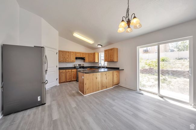 Kitchen featuring stainless steel appliances, dark countertops, and a chandelier | Image 13