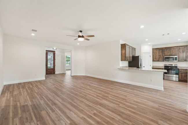 Living room with recessed lighting, Vinyl Wood Plank floor, visible vents, and a ceiling fan | Image 13