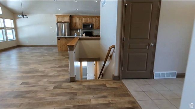 Kitchen with stainless steel appliances, a sink, baseboards, light wood-type flooring, and recessed lighting | Image 20