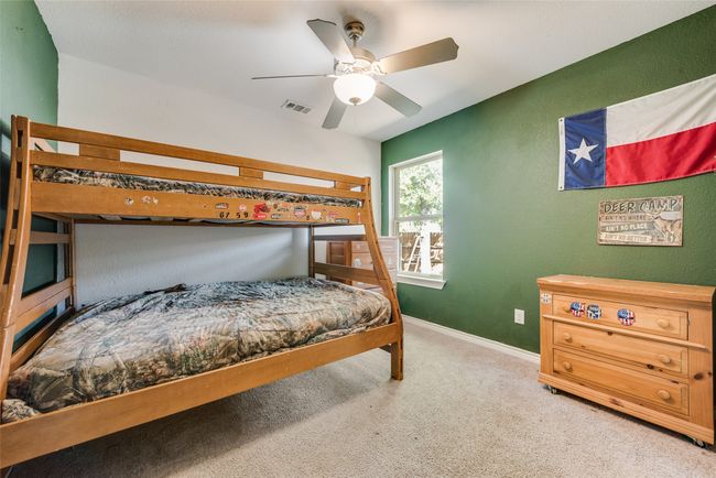 Bedroom with visible vents, baseboards, a ceiling fan, a textured wall, and carpet flooring | Image 17