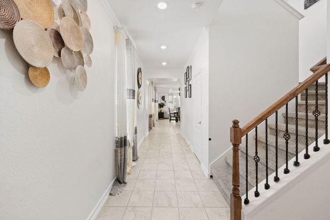 Hallway featuring arched walkways, recessed lighting, ornamental molding, light tile patterned floors, and stairs | Image 6