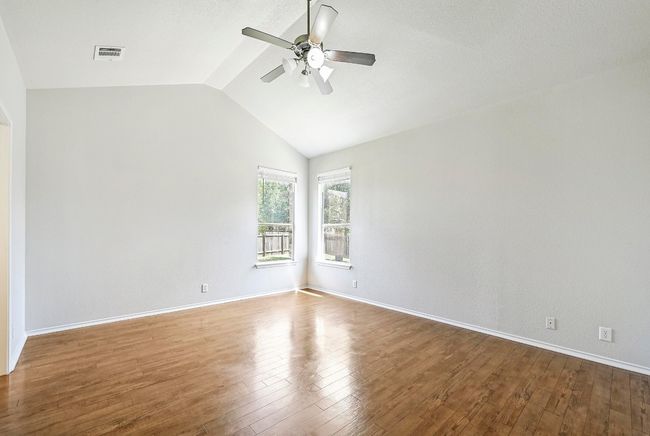 Unfurnished room with a ceiling fan, lofted ceiling, and wood finished floors | Image 14