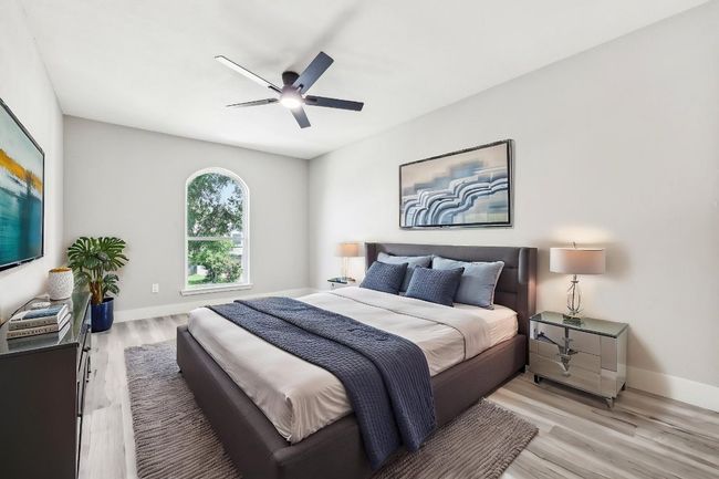Bedroom with light wood-style flooring, baseboards, and ceiling fan | Image 7