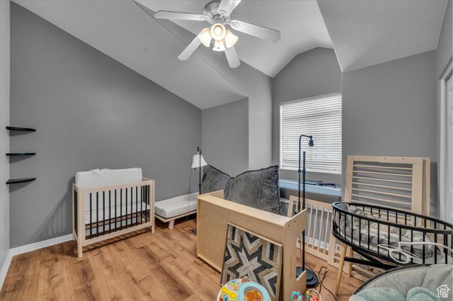 Bedroom with vaulted ceiling, a ceiling fan, baseboards, and wood finished floors | Image 28