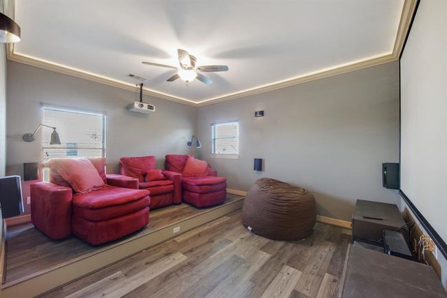 Two level media room with multiple types of lighting and ceiling fan. Sellers are leaving everything in the media room: all furniture, projector, screen, receiver, speakers and all the DVD's | Image 29