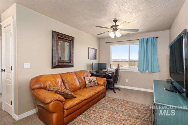 Carpeted home office with ceiling fan and a textured ceiling | Image 16