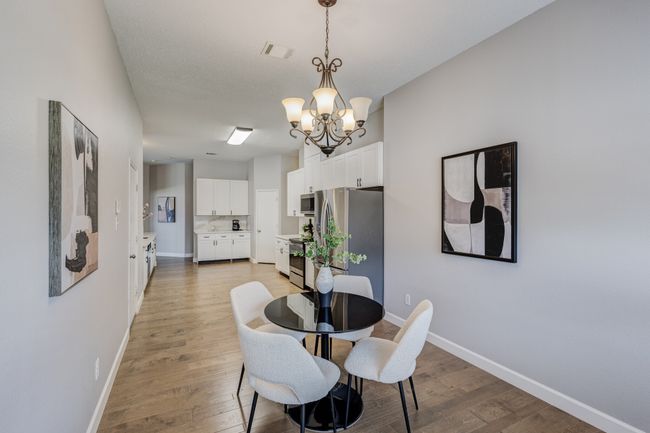 Dining space with a chandelier, light wood-style floors, and baseboards | Image 13