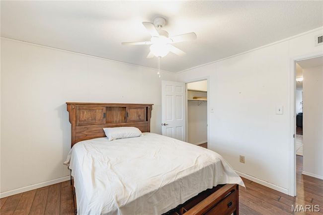 Bedroom with wood-type flooring and ceiling fan | Image 40
