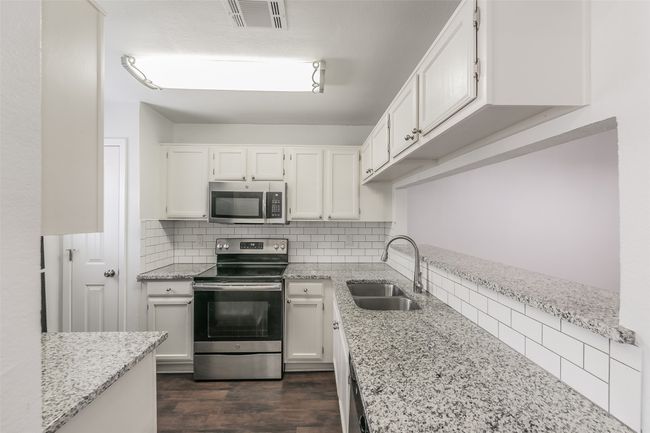 Kitchen featuring stainless steel appliances, granite countertops, and subway tile backsplash | Image 11