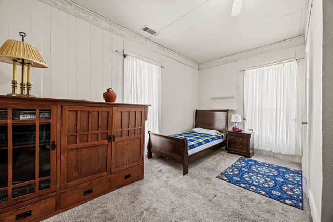 Bedroom featuring carpet, visible vents, crown molding, and multiple windows | Image 19
