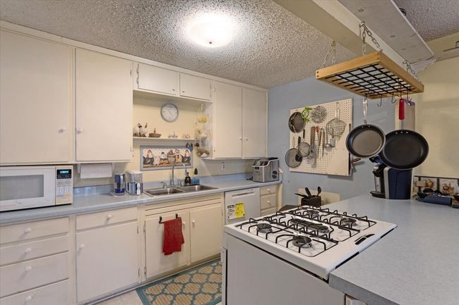 Galley kitchen with gas cooktop and dishwasher. | Image 15
