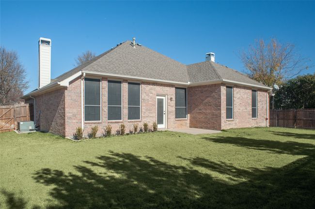 Rear view of house with a chimney, brick siding, and roof with shingles | Image 20