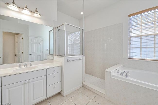 Bathroom with shower with separate bathtub, plenty of natural light, tile patterned floors, and vanity | Image 37