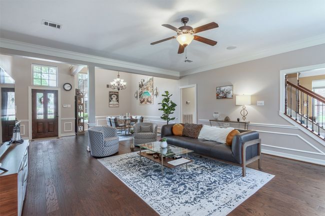 Living room with ceiling fan, and dark wood flooring | Image 8
