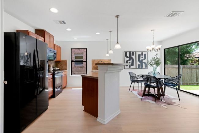 A centrally placed breakfast bar sits between the kitchen and dining area to create an easy, open flow that's great for both daily life and entertaining. | Image 8