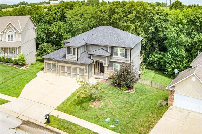 View of front facade featuring roof with shingles, stone siding, concrete driveway, and an attached garage | Image 50