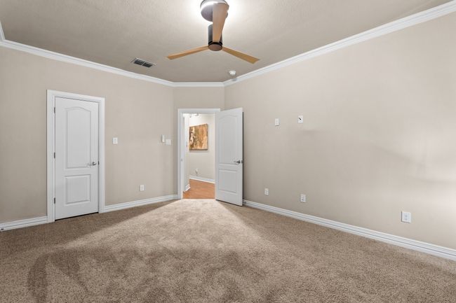 Unfurnished bedroom with crown molding, light carpet, and a ceiling fan | Image 32