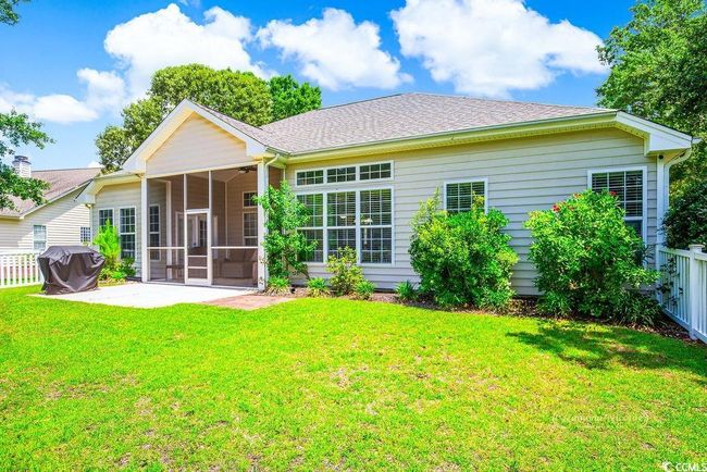 Rear view of property with a sunroom, a patio, and roof with shingles | Image 29