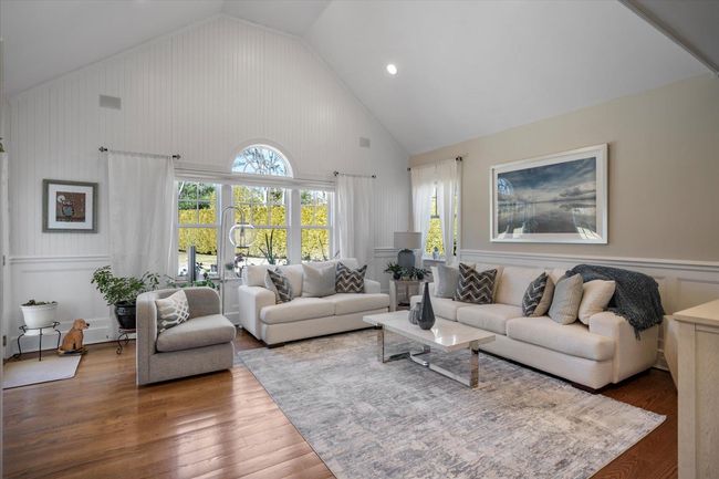 Living room with high vaulted ceiling and wood finished floors | Image 19