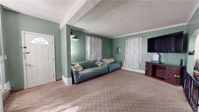 Living room featuring carpet floors, crown molding, and a textured ceiling | Image 2