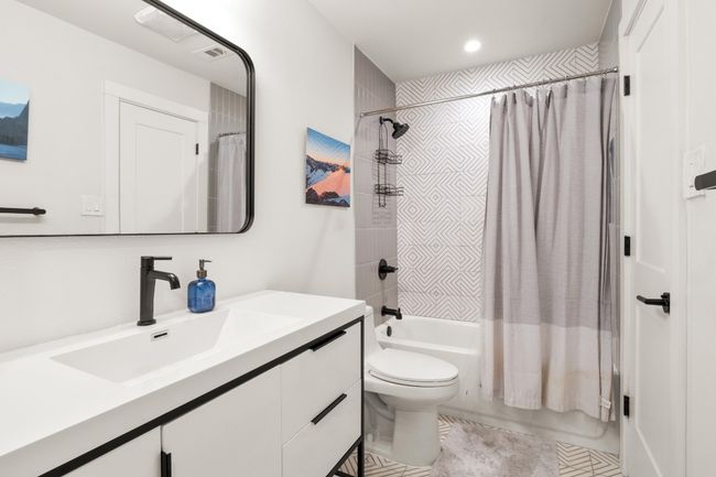 Full bathroom featuring shower / bath combination with curtain, toilet, vanity, tile patterned flooring, and recessed lighting | Image 11