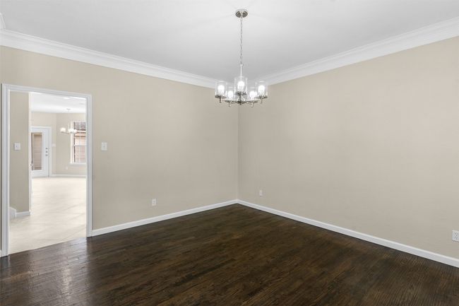 Unfurnished room featuring ornamental molding, a notable chandelier, baseboards, and wood finished floors | Image 8