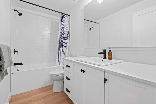 Bathroom featuring vanity, toilet, shower / bath combo, and wood finished floors | Image 32
