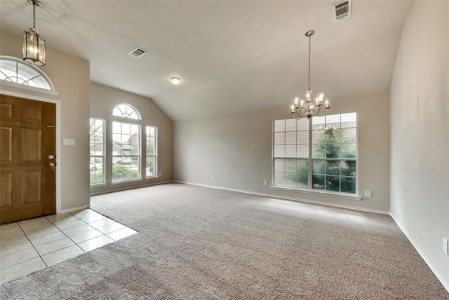 Entryway featuring a chandelier, carpet flooring, lofted ceiling, and tile patterned floors | Image 4