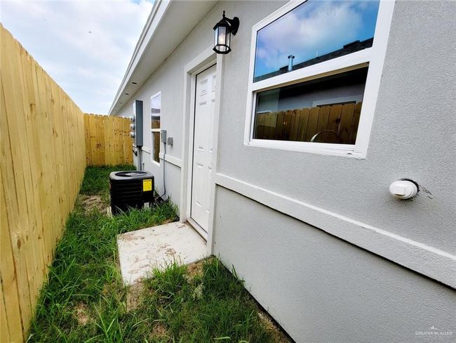 View of side of property with central AC, fence, and stucco siding | Image 24