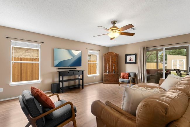 Living area featuring a ceiling fan, wood finished floors, and baseboards. | Image 13