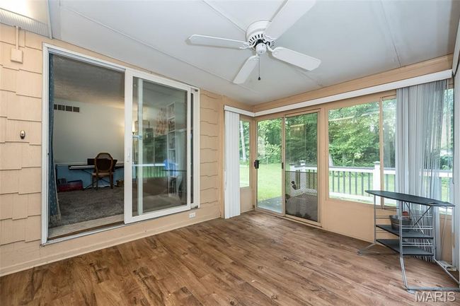 Sunroom featuring a ceiling fan, a wooden deck, and wood finished floors | Image 19