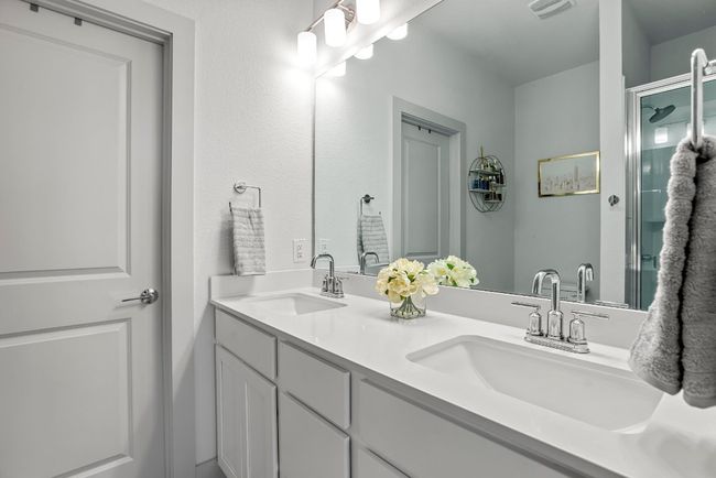 The primary ensuite is simple elegance—with dual sinks and an roomy walk in shower. | Image 13