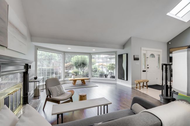 Living area with vaulted ceiling, plenty of natural light, a fireplace, wood finished floors, and recessed lighting | Image 5