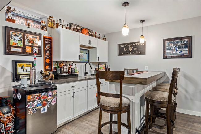 Kitchen with hanging light fixtures, white cabinets, and light hardwood / wood-style flooring | Image 38
